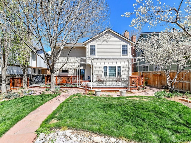 rear view of property featuring a pergola, a deck, a fenced backyard, a chimney, and a yard