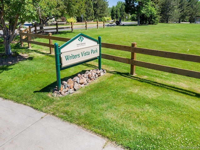 community sign with a lawn and fence