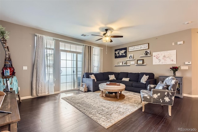 living area with baseboards, a ceiling fan, dark wood-style flooring, and visible vents