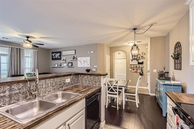 kitchen with wooden counters, visible vents, dishwasher, a sink, and dark wood-type flooring