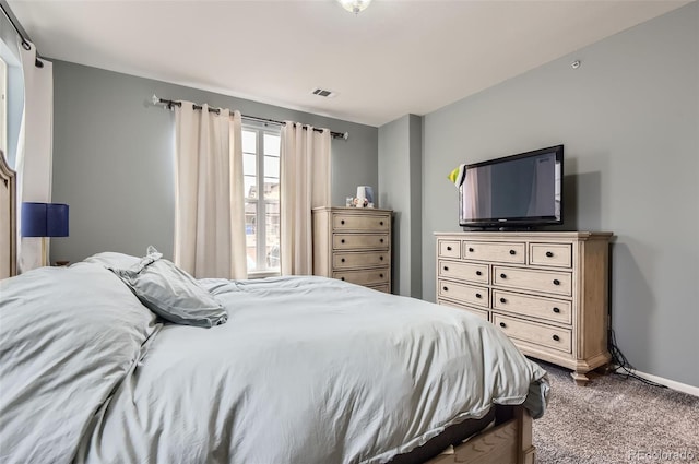 bedroom with baseboards, dark carpet, and visible vents