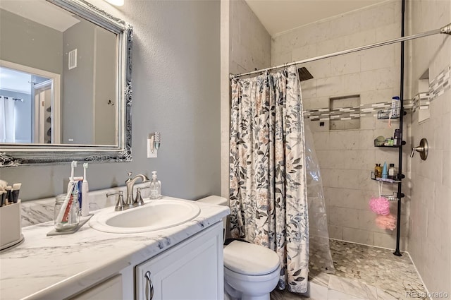 bathroom featuring vanity, a tile shower, toilet, and visible vents