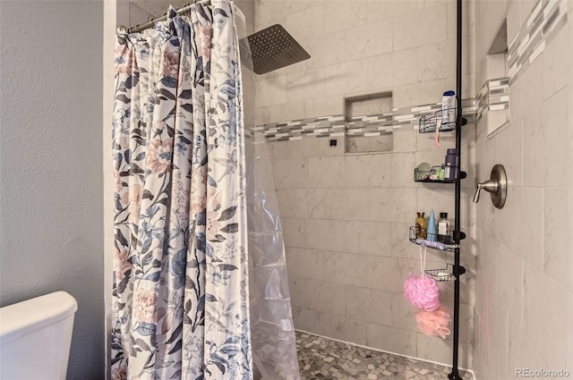 full bath featuring a stall shower and toilet