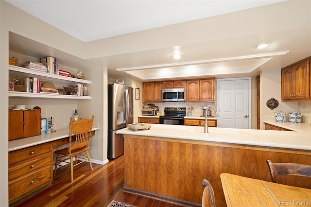 kitchen featuring kitchen peninsula, appliances with stainless steel finishes, and decorative backsplash