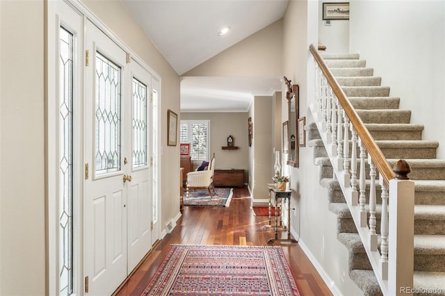 entrance foyer with lofted ceiling, ornamental molding, and dark hardwood / wood-style floors