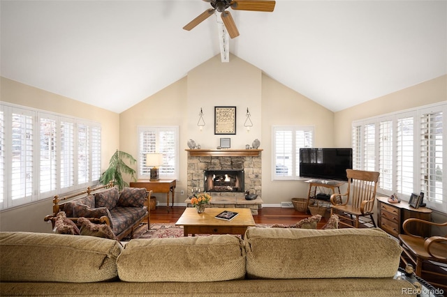 living room featuring ceiling fan, a stone fireplace, hardwood / wood-style floors, and vaulted ceiling with beams