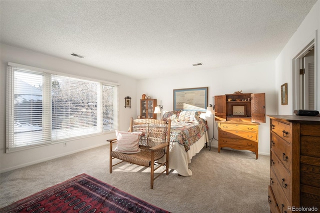 bedroom with a textured ceiling and light carpet