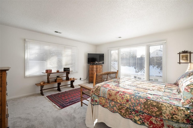 bedroom featuring a textured ceiling and light colored carpet