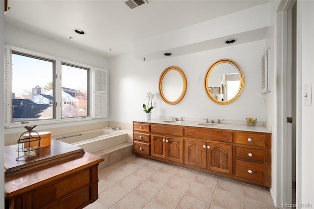 bathroom with a relaxing tiled tub, tile patterned floors, and vanity