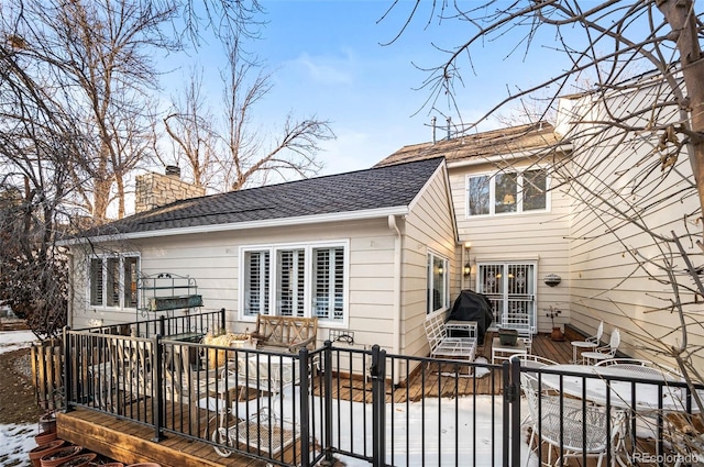 snow covered back of property featuring a wooden deck