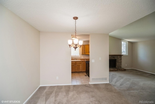 7325 S Houstoun Waring Cir, Littleton, CO 80120 - unfurnished dining area with light colored carpet, plenty of natural light, a chandelier, a brick fireplace, and a textured ceiling