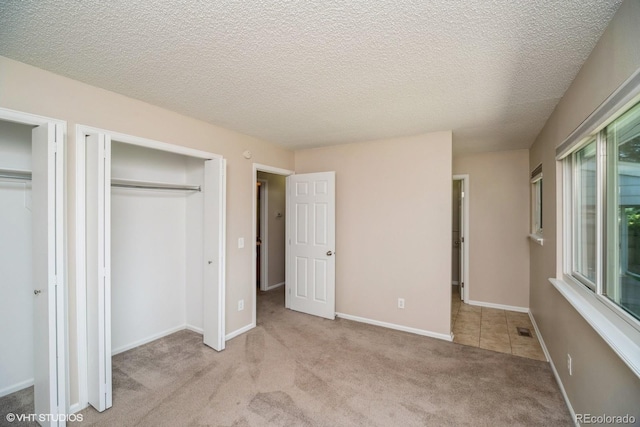 7325 S Houstoun Waring Cir, Littleton, CO 80120 - unfurnished bedroom featuring carpet, multiple closets, and a textured ceiling