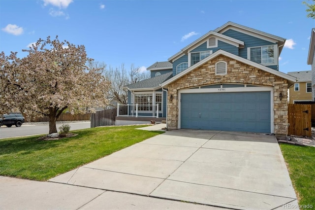 4290 Cottonwood Lakes Blvd, Thornton, CO 80241 - view of front of house with driveway, a front yard, fence, an attached garage, and stone siding