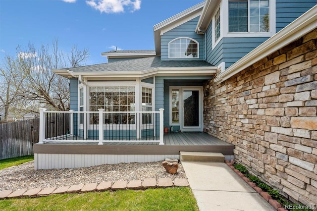 4290 Cottonwood Lakes Blvd, Thornton, CO 80241 - entrance to property with stone siding, fence, a wooden deck, and roof with shingles