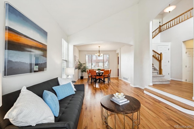 4290 Cottonwood Lakes Blvd, Thornton, CO 80241 - living area with arched walkways, high vaulted ceiling, a chandelier, visible vents, and stairway