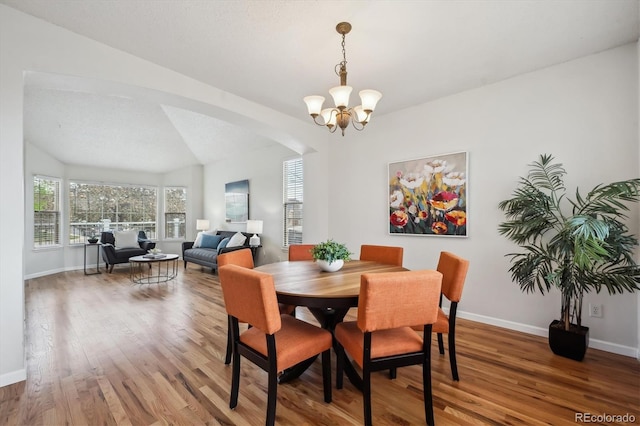 4290 Cottonwood Lakes Blvd, Thornton, CO 80241 - dining area with baseboards, arched walkways, light wood finished floors, and a notable chandelier