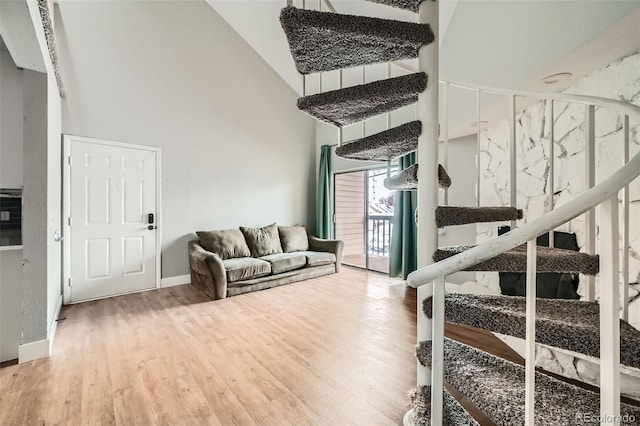 living room with hardwood / wood-style flooring and high vaulted ceiling