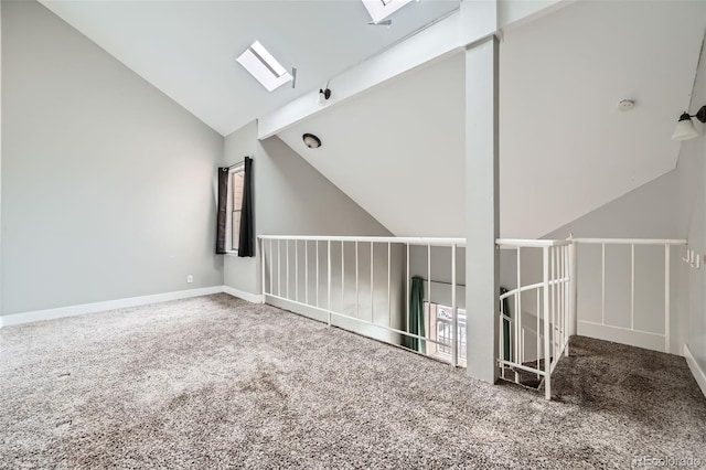 carpeted spare room featuring lofted ceiling with skylight