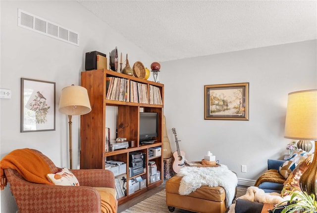 living room with wood-type flooring and a textured ceiling