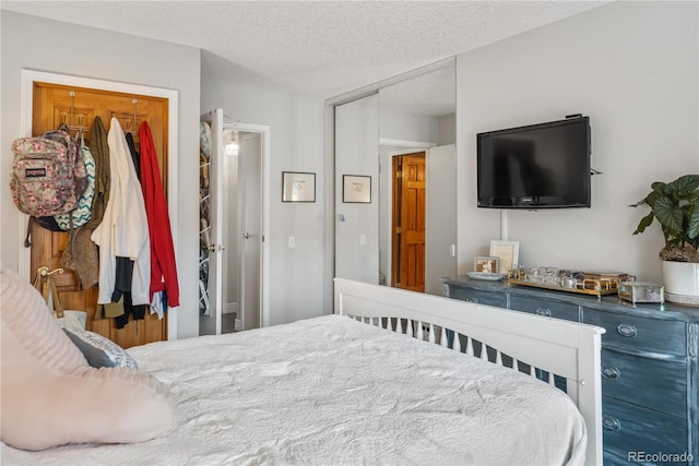 bedroom with a textured ceiling and a closet