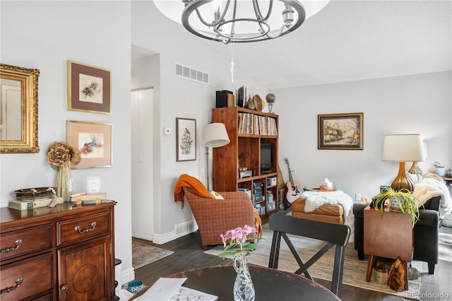 living room with dark wood-type flooring and a chandelier