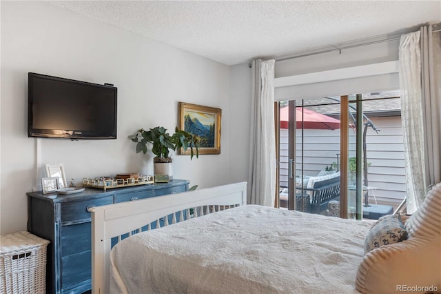 bedroom featuring a textured ceiling and access to outside