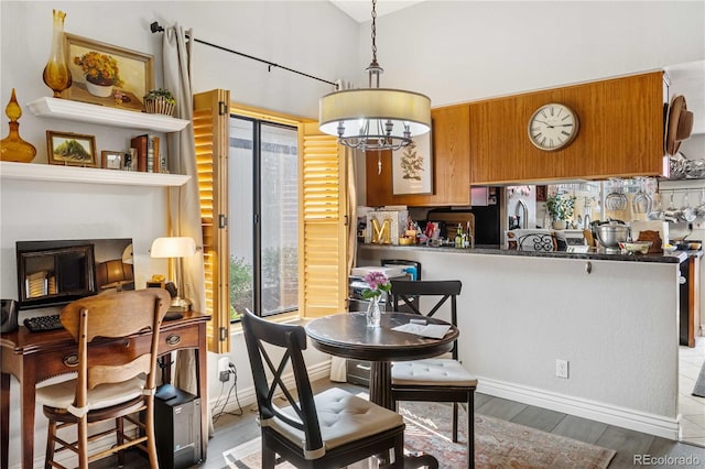 dining area featuring an inviting chandelier, light hardwood / wood-style flooring, and lofted ceiling