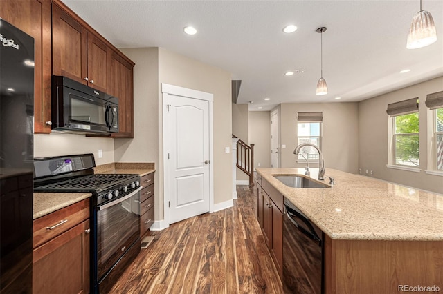 kitchen with hanging light fixtures, recessed lighting, dark wood-style floors, black appliances, and a sink