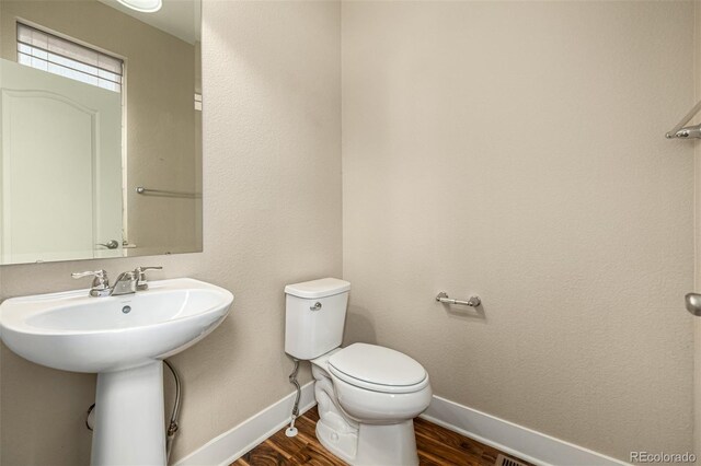 bathroom with sink, wood-type flooring, and toilet