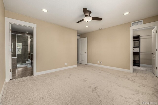 unfurnished bedroom featuring connected bathroom, light colored carpet, and ceiling fan