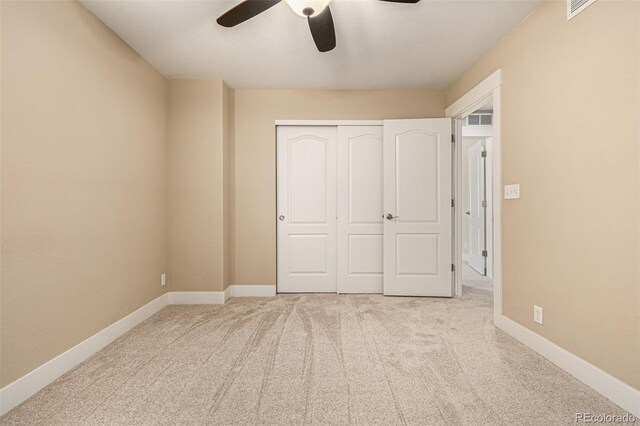 unfurnished bedroom with light carpet, a closet, and ceiling fan