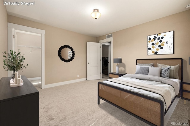 bedroom with visible vents, baseboards, washer / clothes dryer, a spacious closet, and light colored carpet