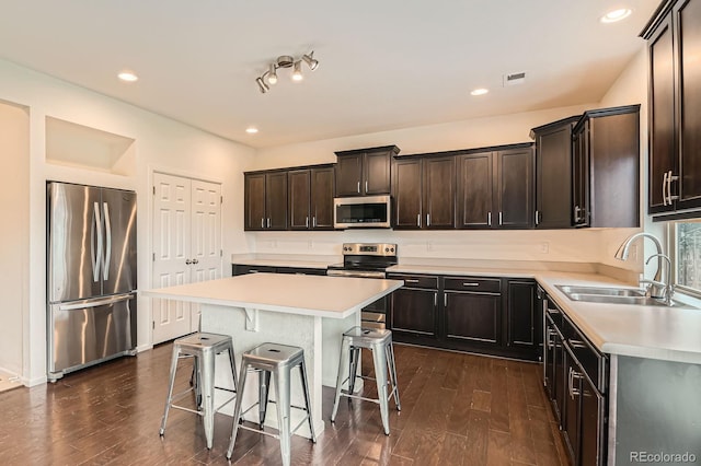 12981 E 108th Way, Commerce City, CO 80022 - kitchen featuring stainless steel appliances, a breakfast bar area, light countertops, dark wood finished floors, and recessed lighting
