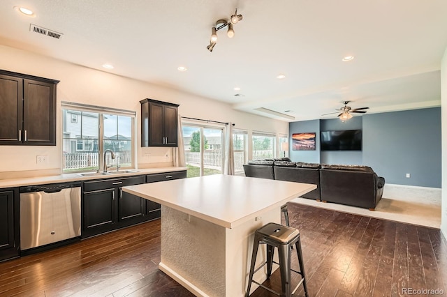 12981 E 108th Way, Commerce City, CO 80022 - kitchen featuring dishwasher, dark wood finished floors, light countertops, a breakfast bar, and a kitchen island