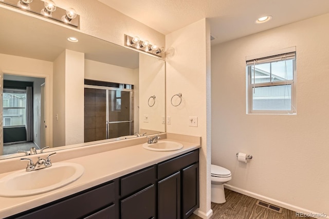 12981 E 108th Way, Commerce City, CO 80022 - full bathroom with double vanity, a stall shower, and wood finished floors