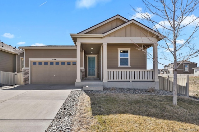 view of front of property featuring fence, driveway, covered porch, a garage, and board and batten siding