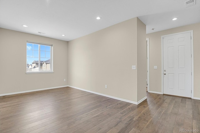 unfurnished room featuring visible vents, baseboards, and wood finished floors