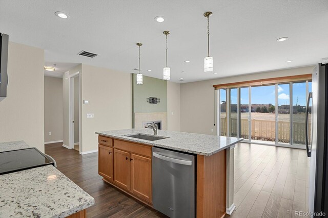 kitchen with visible vents, a kitchen island with sink, dark wood-style flooring, stainless steel appliances, and a sink