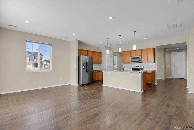 kitchen featuring visible vents, appliances with stainless steel finishes, open floor plan, and light countertops