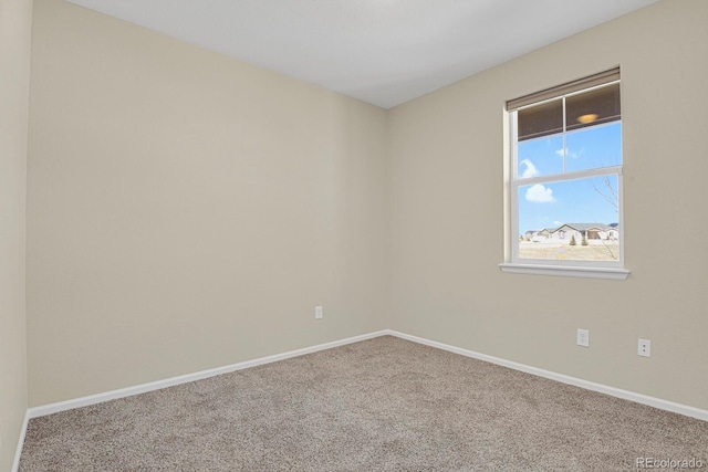 empty room featuring baseboards and carpet