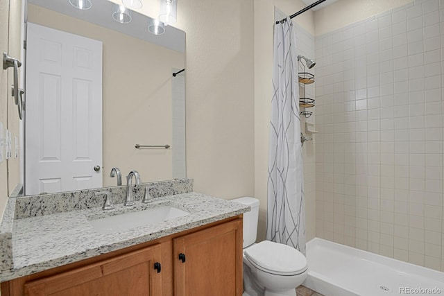 bathroom featuring vanity, toilet, and tiled shower