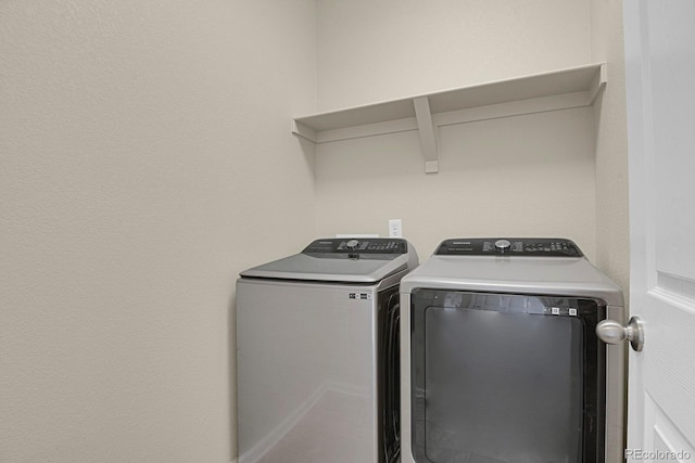 washroom featuring laundry area and washing machine and clothes dryer