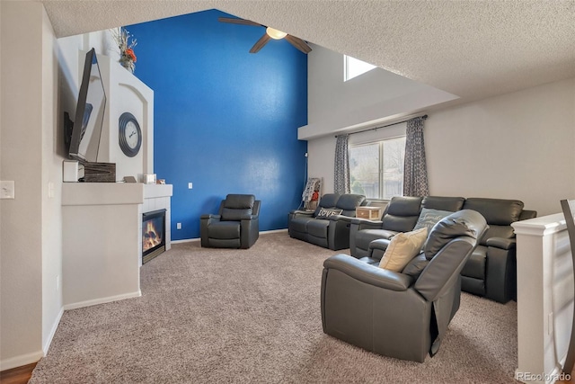 living room with a textured ceiling, ceiling fan, carpet floors, a fireplace, and lofted ceiling