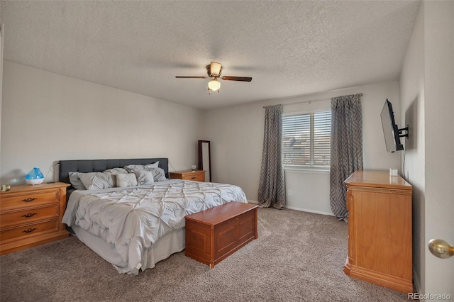 bedroom featuring ceiling fan, a textured ceiling, baseboards, and light carpet