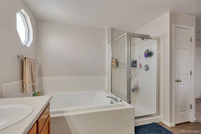 full bathroom featuring a bath, wood finished floors, vanity, and a stall shower