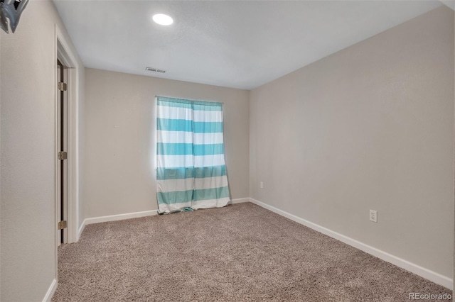 unfurnished room featuring carpet floors, visible vents, and baseboards
