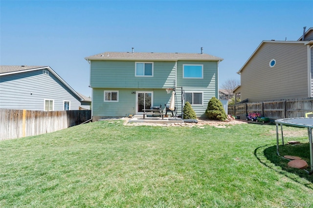 back of property with a patio area, a lawn, and a fenced backyard