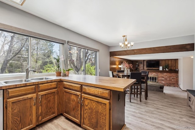 7942 S Vincennes Way, Centennial, CO 80112 - kitchen with a peninsula, light wood-style floors, open floor plan, a chandelier, and a sink