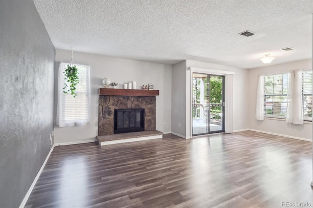 10950 W Florida Ave Unit 314, Lakewood, CO 80232 - unfurnished living room featuring dark wood-style floors, a stone fireplace, and a textured ceiling
