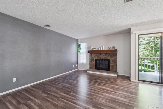 10950 W Florida Ave Unit 314, Lakewood, CO 80232 - unfurnished living room featuring dark wood-style floors, a textured ceiling, and a stone fireplace